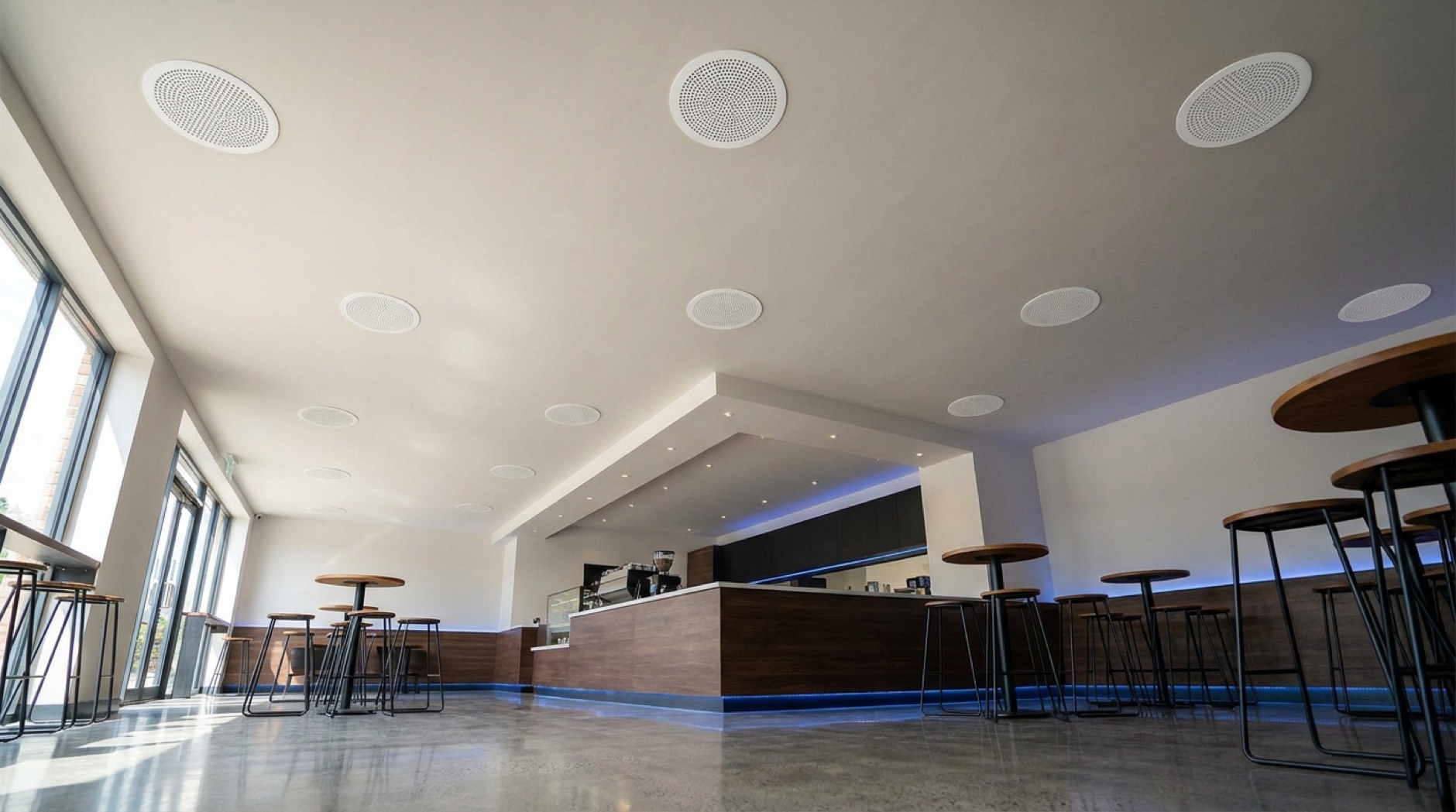 A modern cafe with flush in-ceiling speakers and no screens